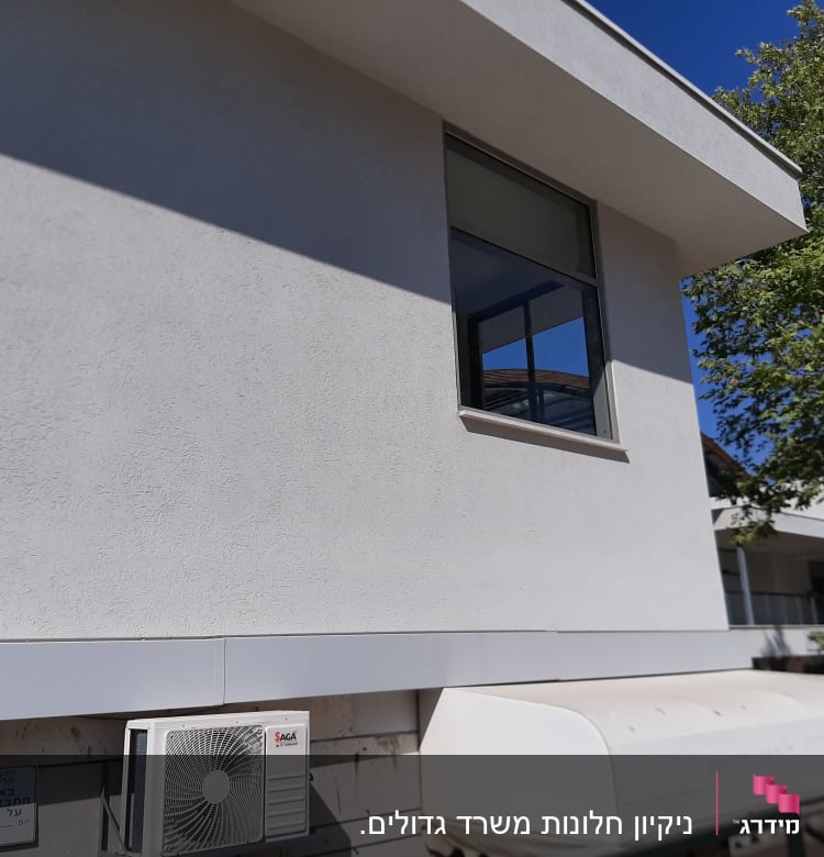 קיר חיצוני עם מזגן, חלון פתוח ועץ קרוב